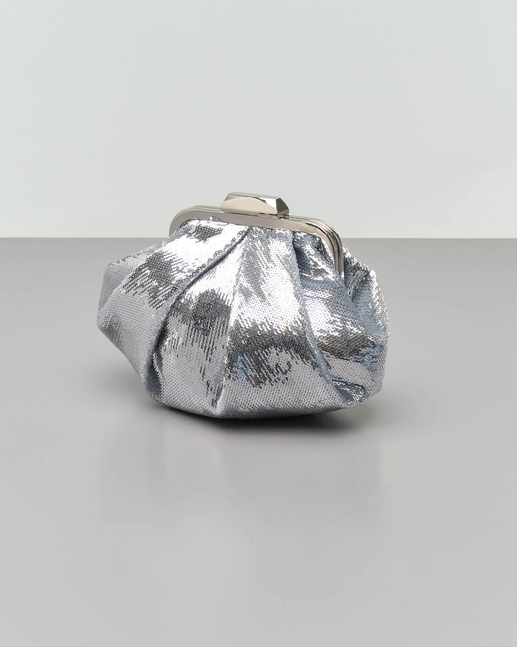 Clutch in paillettes argento con pieghe e chiusura a scatto in metallo