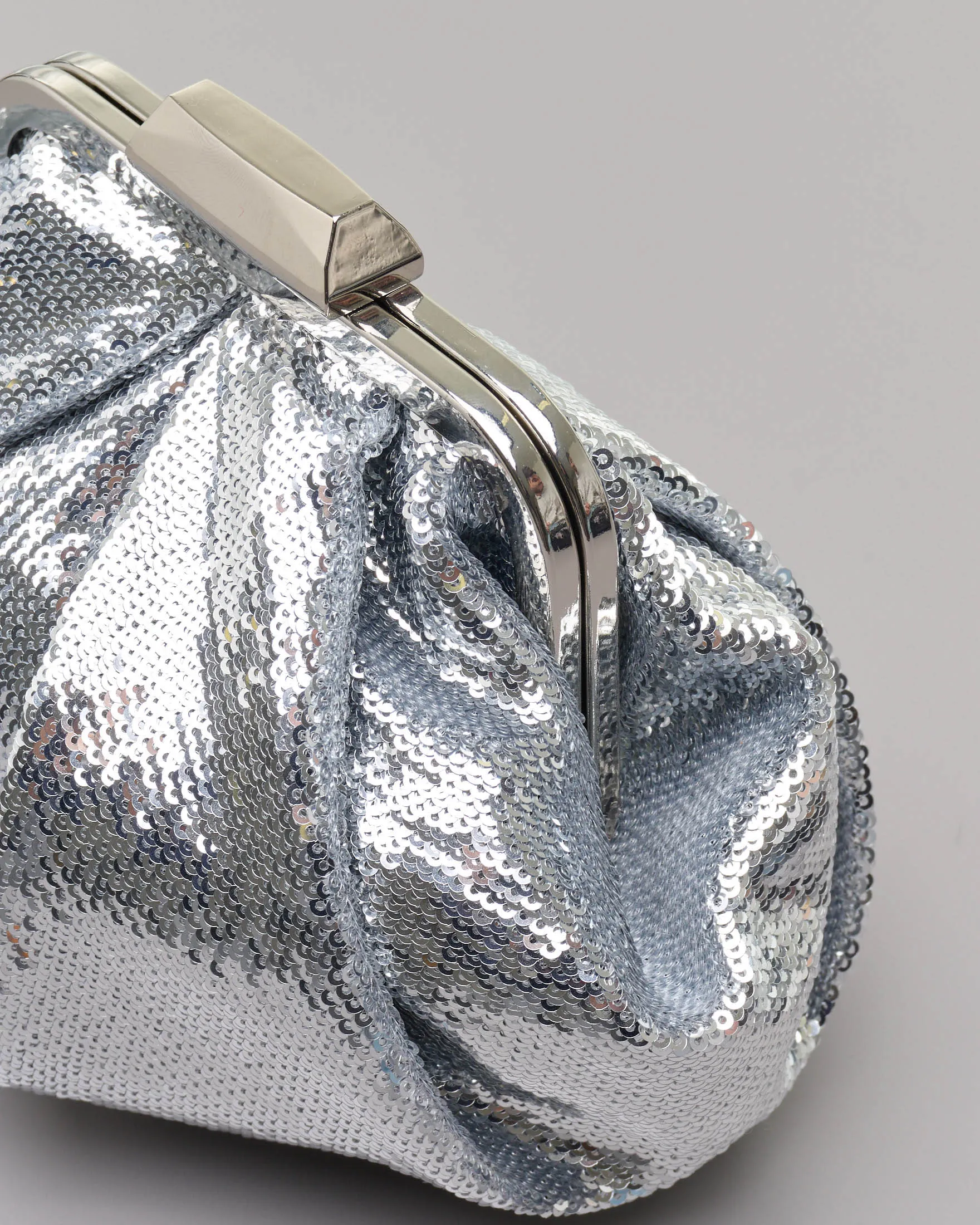 Clutch in paillettes argento con pieghe e chiusura a scatto in metallo