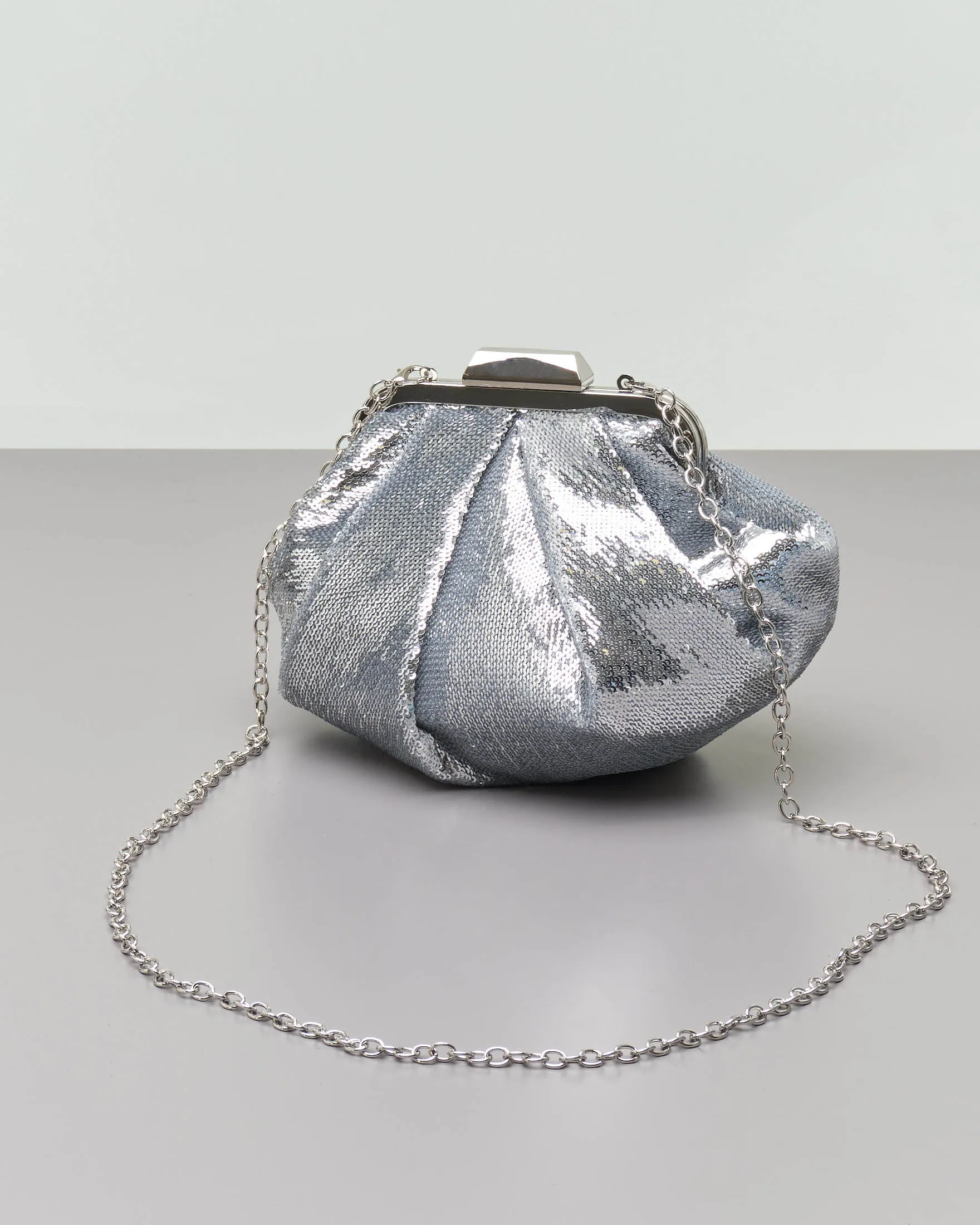 Clutch in paillettes argento con pieghe e chiusura a scatto in metallo