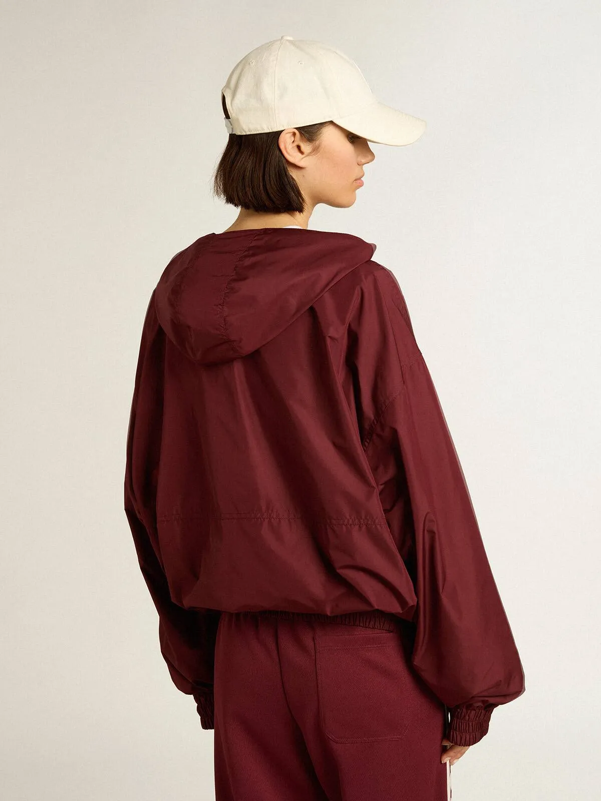 Giacca a vento di colore bordeaux con cappuccio